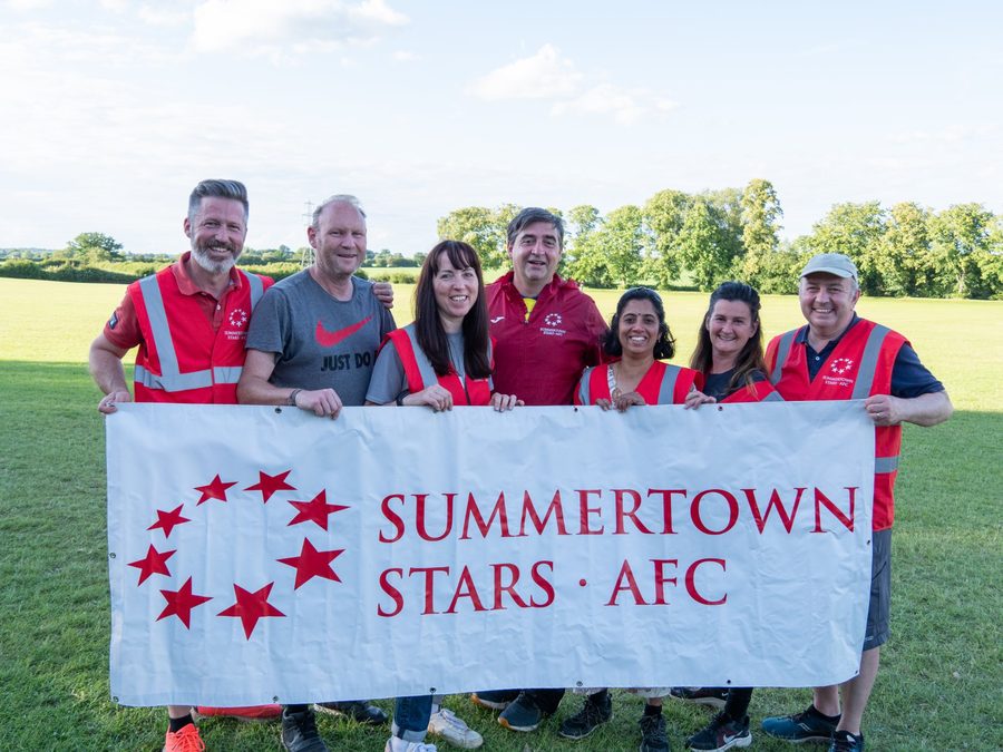 Tournament volunteers holding the Summertown Stars AFC banner